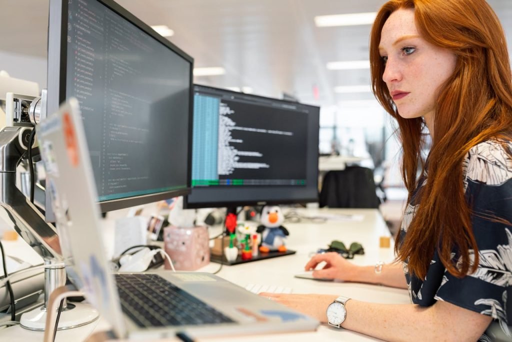 A software engineer working at a multi-monitor desk