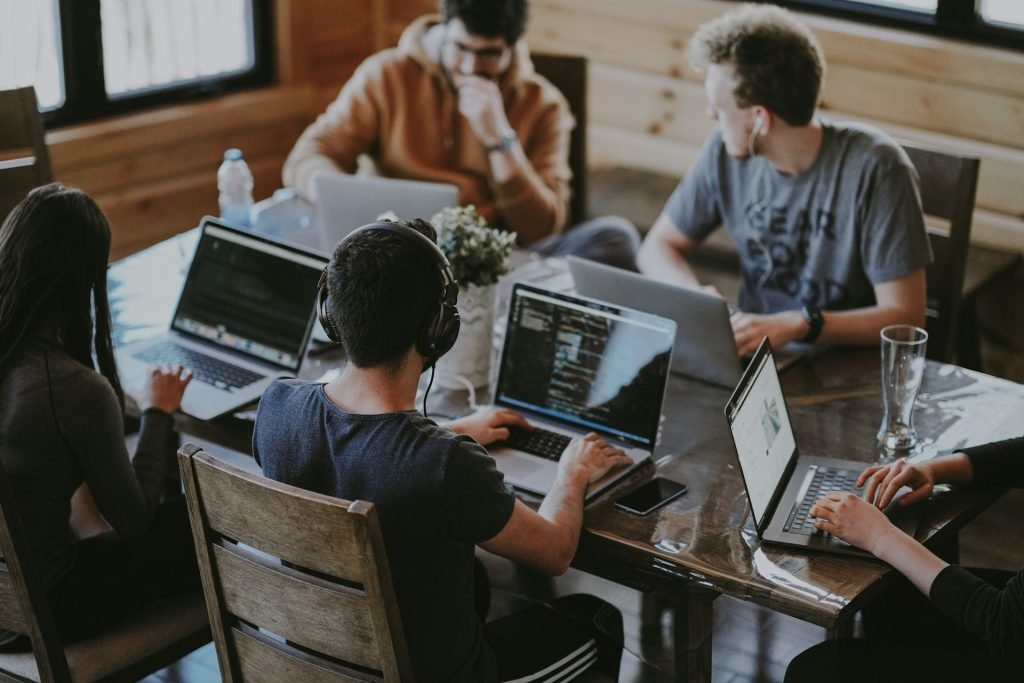 Engineers working on laptops around a shared table