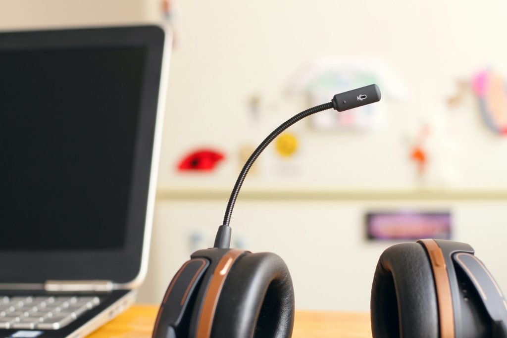 A headset next to a laptop on a desk