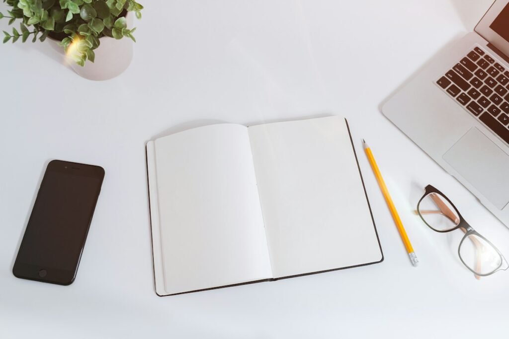 A notebook and laptop set up for a weekly update